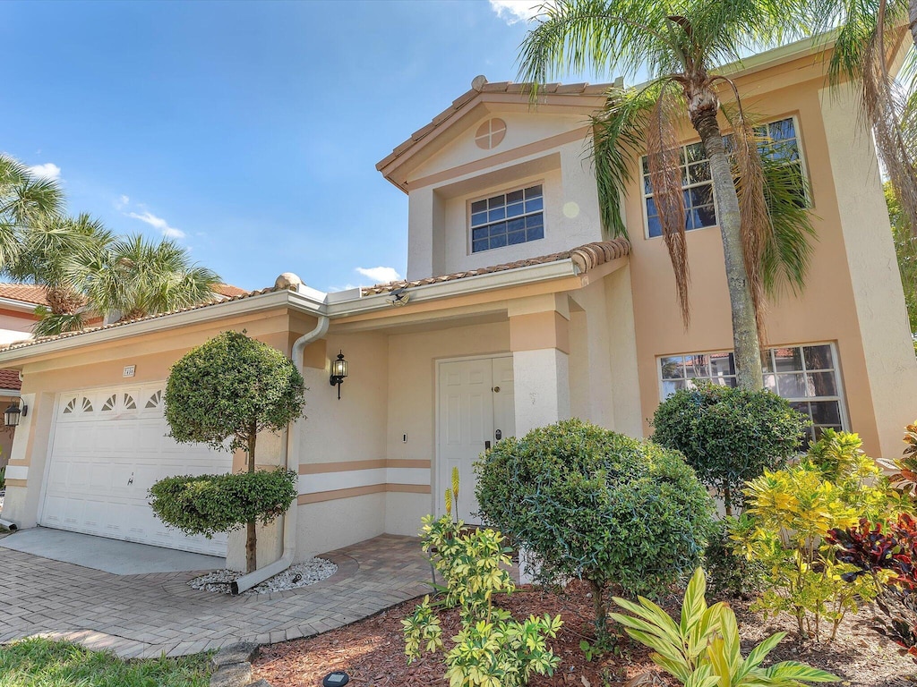 7456 NW 25th St, Margate, FL 33063 - view of front facade with an attached garage, a tiled roof, and stucco siding