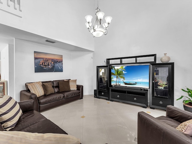 living room with a high ceiling, tile patterned flooring, visible vents, and an inviting chandelier