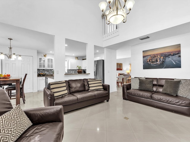 living room featuring light tile patterned floors, recessed lighting, visible vents, a towering ceiling, and an inviting chandelier