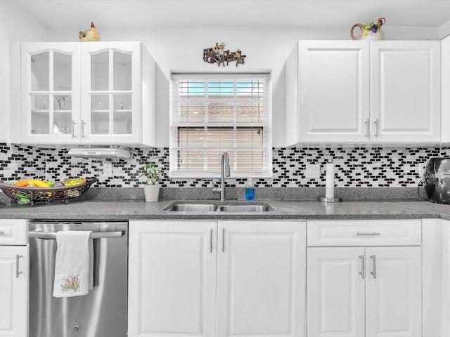 kitchen featuring a sink, white cabinets, stainless steel dishwasher, decorative backsplash, and glass insert cabinets