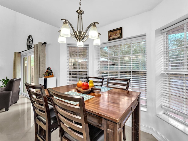 dining area with light tile patterned floors and an inviting chandelier