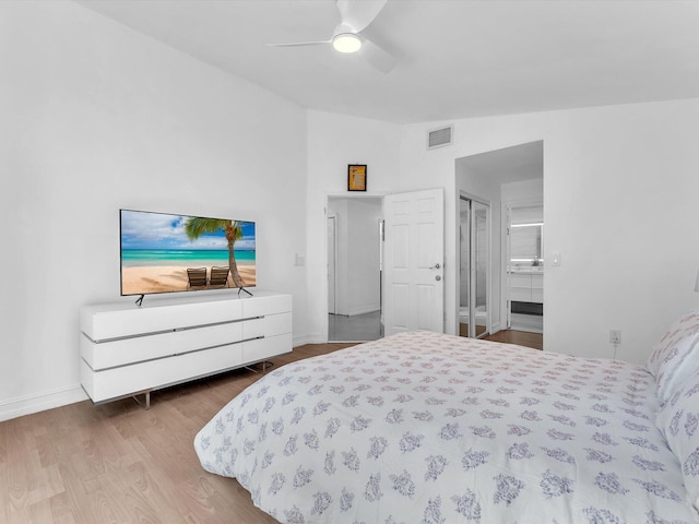 bedroom featuring visible vents, a ceiling fan, vaulted ceiling, wood finished floors, and baseboards