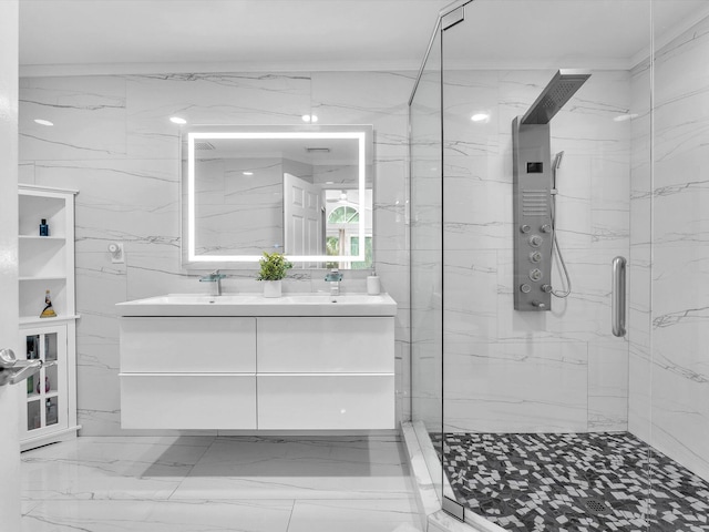 bathroom with a sink, double vanity, a marble finish shower, and tile walls