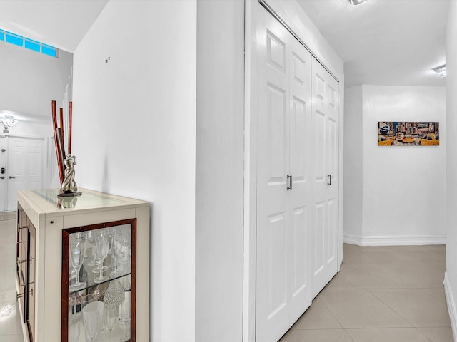 hallway with light tile patterned flooring and baseboards