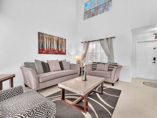 living room featuring tile patterned floors, a towering ceiling, and baseboards