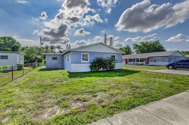 view of front facade featuring a front lawn, fence, and stucco siding