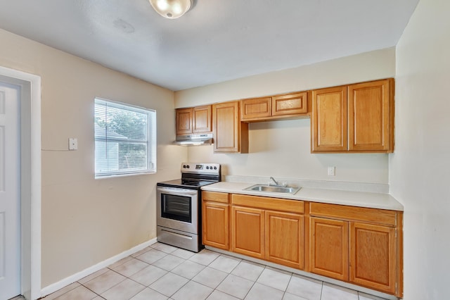 kitchen with brown cabinets, light countertops, a sink, stainless steel range with electric stovetop, and under cabinet range hood