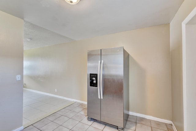 kitchen featuring baseboards, stainless steel fridge with ice dispenser, and light tile patterned floors