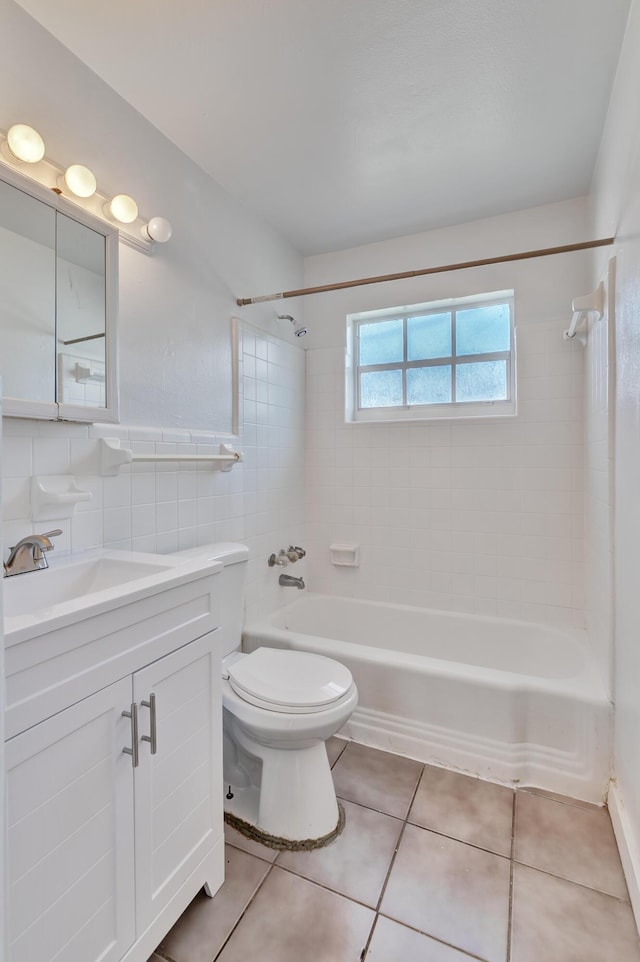 bathroom featuring toilet, tile patterned flooring, tub / shower combination, vanity, and tile walls