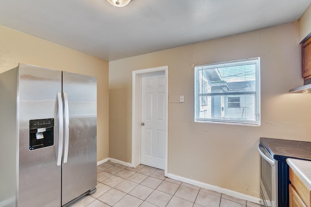 kitchen featuring stainless steel appliances, baseboards, and light tile patterned floors