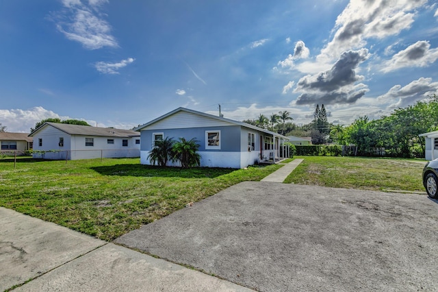 view of front of property featuring fence, a front lawn, and brick siding