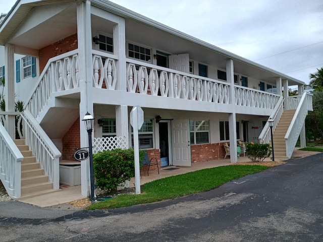 view of front of property featuring brick siding and stairway