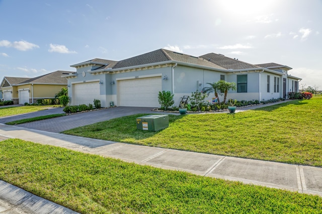 ranch-style house featuring driveway, roof with shingles, an attached garage, a front yard, and stucco siding