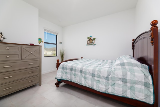 bedroom with light tile patterned floors and baseboards