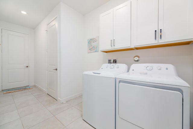 washroom featuring cabinet space, baseboards, light tile patterned flooring, and independent washer and dryer