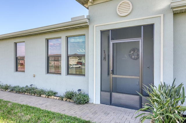 doorway to property featuring stucco siding