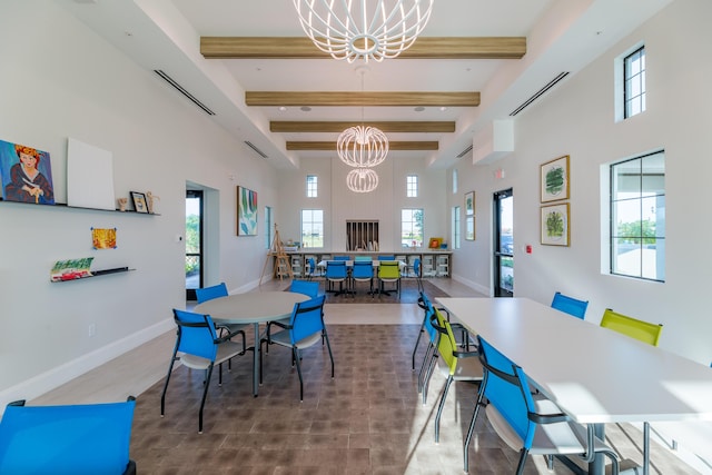 dining area with a notable chandelier, a high ceiling, a healthy amount of sunlight, beamed ceiling, and baseboards