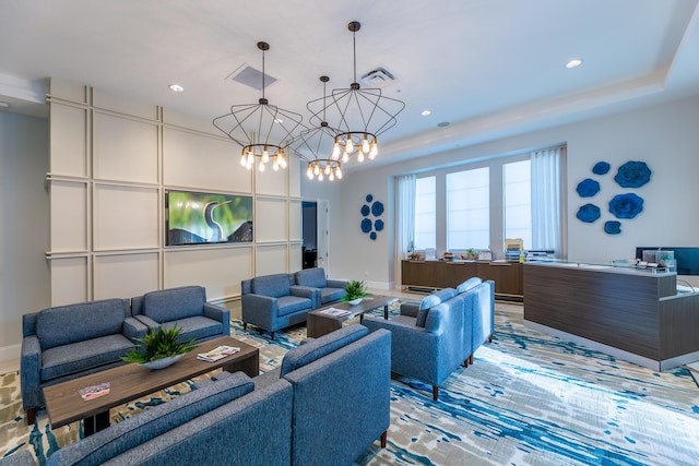 living area with a chandelier, a raised ceiling, visible vents, and recessed lighting