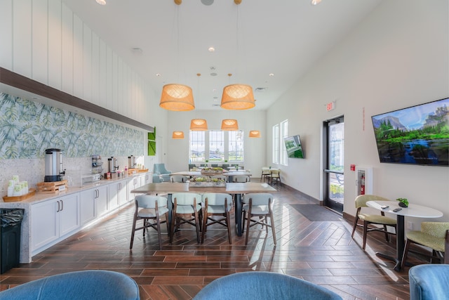 dining area featuring wood finish floors and a high ceiling