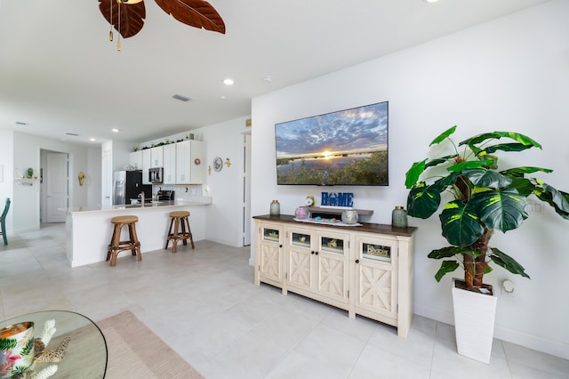 living area with ceiling fan, visible vents, baseboards, and recessed lighting