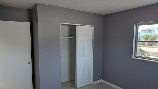 unfurnished bedroom with a closet and baseboards