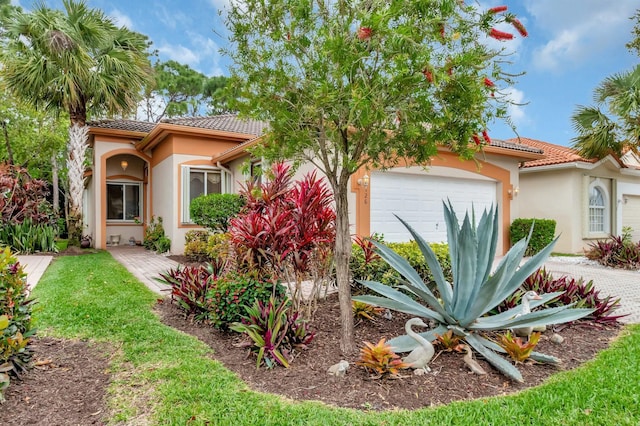 view of front of home featuring a garage, a tile roof, and stucco siding