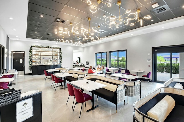 dining area with a towering ceiling, baseboards, visible vents, and recessed lighting