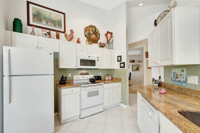 kitchen featuring light stone counters, white appliances, white cabinetry, and light tile patterned floors