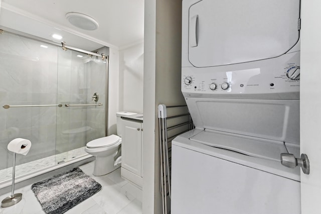 bathroom with a shower stall, stacked washer / dryer, toilet, and marble finish floor