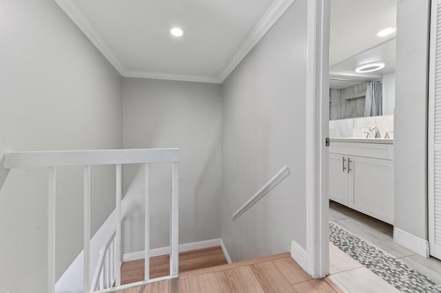 stairway featuring crown molding, wood finished floors, and baseboards