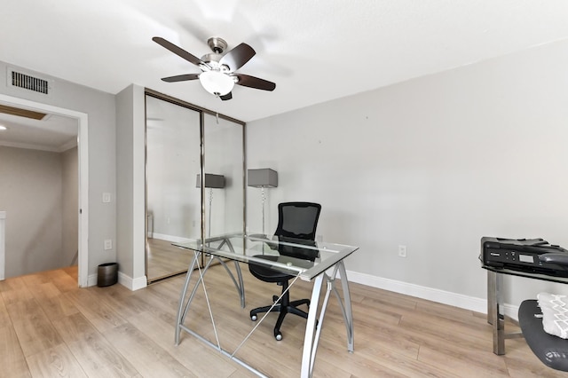 home office with visible vents, light wood-style floors, baseboards, and ceiling fan