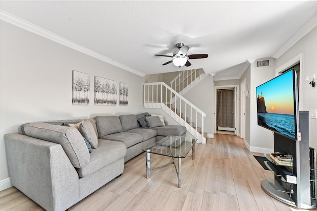 living area featuring stairs, crown molding, light wood-style floors, and visible vents