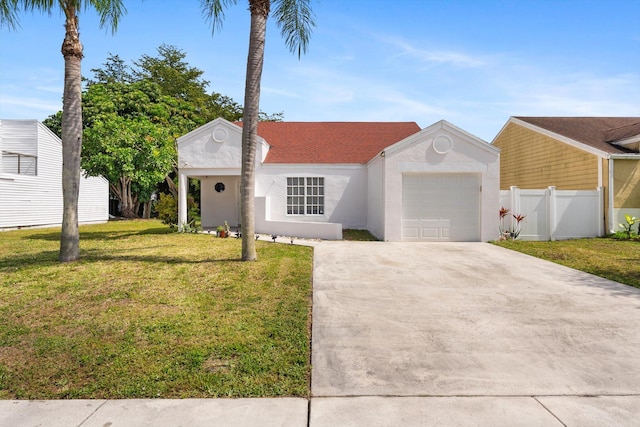 ranch-style home featuring an attached garage, fence, concrete driveway, stucco siding, and a front yard