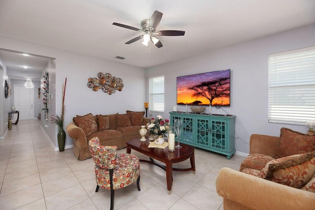 living room featuring light tile patterned floors, ceiling fan, visible vents, and baseboards