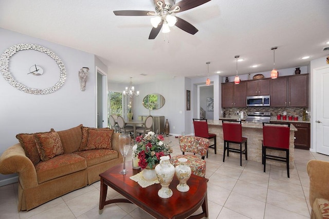 living area with ceiling fan with notable chandelier and light tile patterned flooring