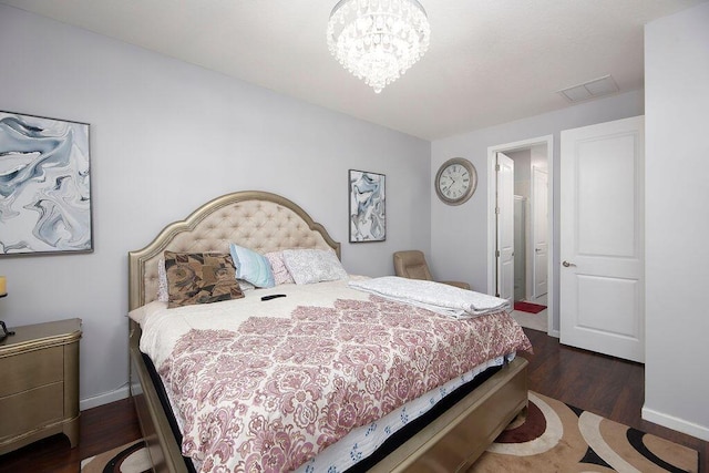 bedroom featuring a chandelier, wood finished floors, visible vents, and baseboards