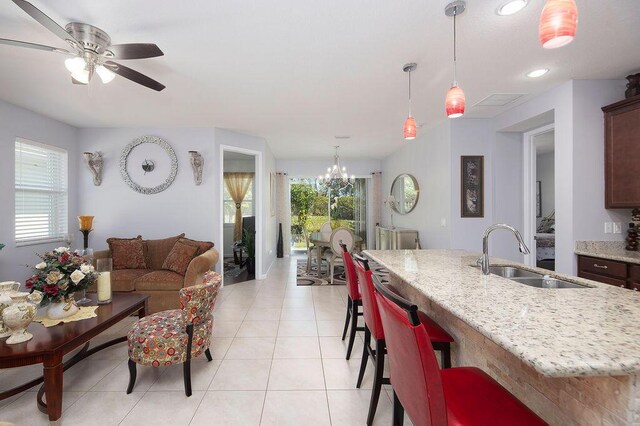 kitchen featuring plenty of natural light, pendant lighting, a sink, and light stone countertops