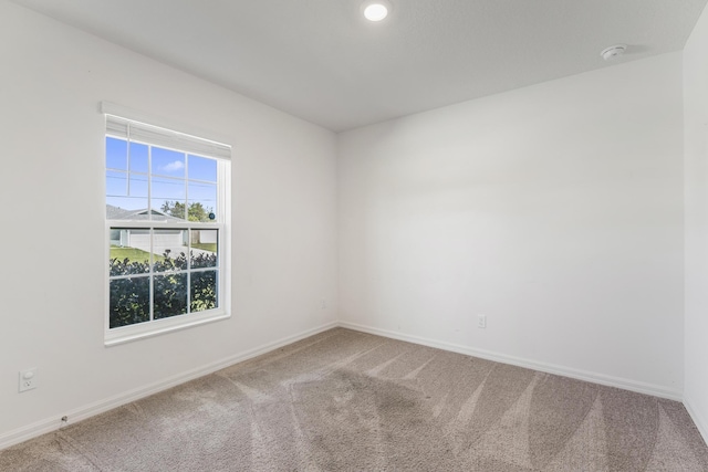 empty room featuring baseboards and carpet floors