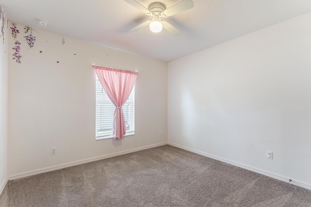 empty room with a ceiling fan, baseboards, and carpet floors