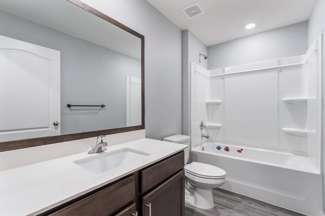 bathroom with vanity, wood finished floors, visible vents, shower / tub combination, and toilet