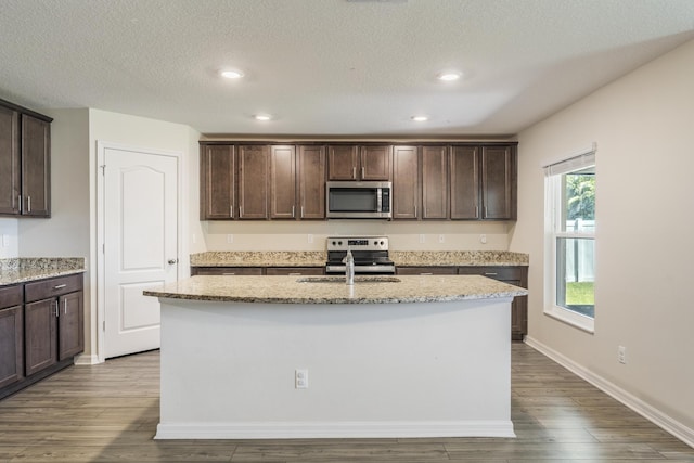 kitchen with stainless steel appliances and dark brown cabinetry