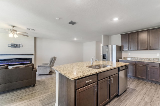 kitchen with a sink, light wood-type flooring, visible vents, and stainless steel appliances