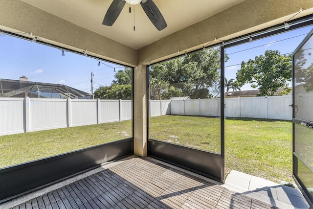 unfurnished sunroom featuring a ceiling fan