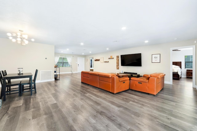 living area featuring baseboards, an inviting chandelier, wood finished floors, and recessed lighting