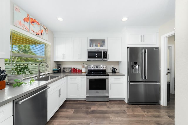 kitchen with stainless steel appliances, dark wood-style flooring, white cabinetry, and a sink