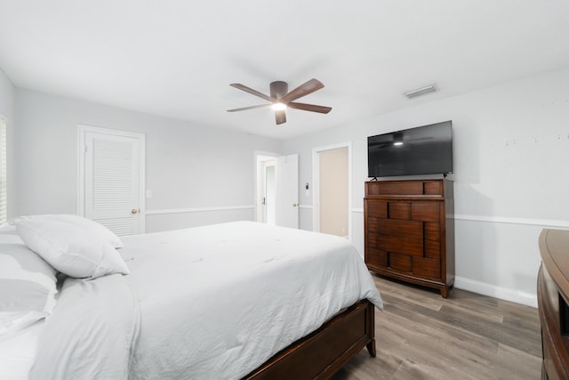 bedroom with ceiling fan, light wood-style flooring, visible vents, baseboards, and a closet