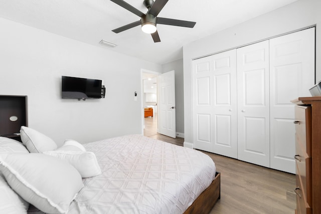 bedroom featuring a closet, visible vents, ceiling fan, and wood finished floors