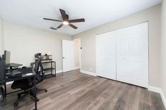 home office featuring visible vents, ceiling fan, baseboards, and wood finished floors