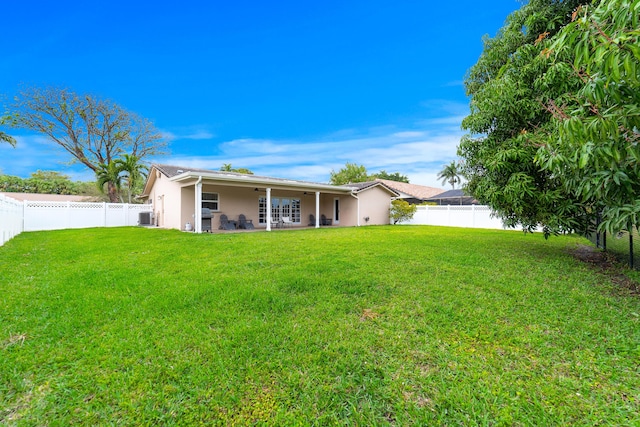 back of property featuring a yard, a patio area, a fenced backyard, and stucco siding