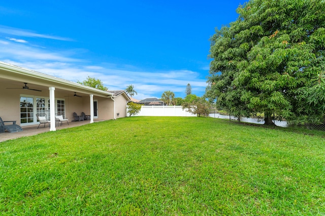 view of yard with a patio area, a fenced backyard, and a ceiling fan